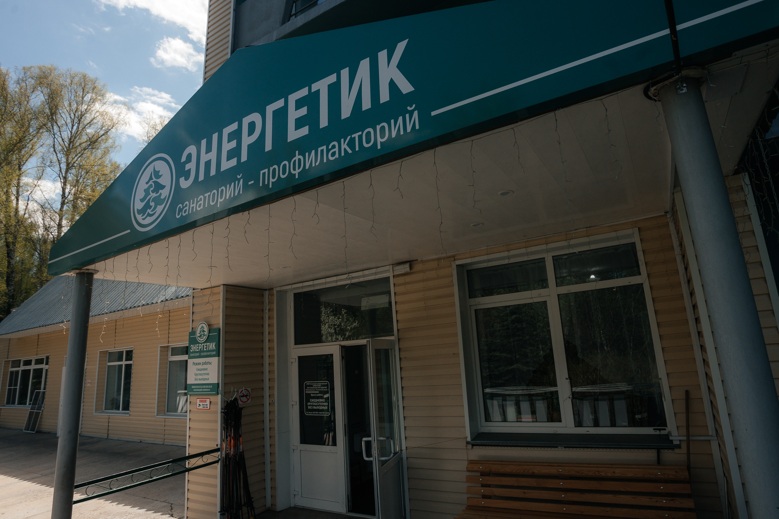 Санаторий Энергетик — корпус с зелёным козырьком среди деревьев летом